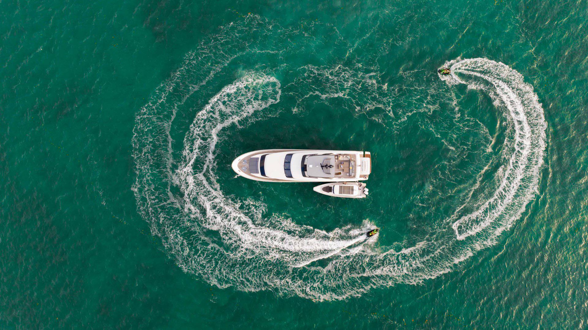 Drone view of luxury yacht and jet skis in Miami waters